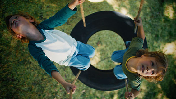 thumbnail version of two boys swinging on tire swing